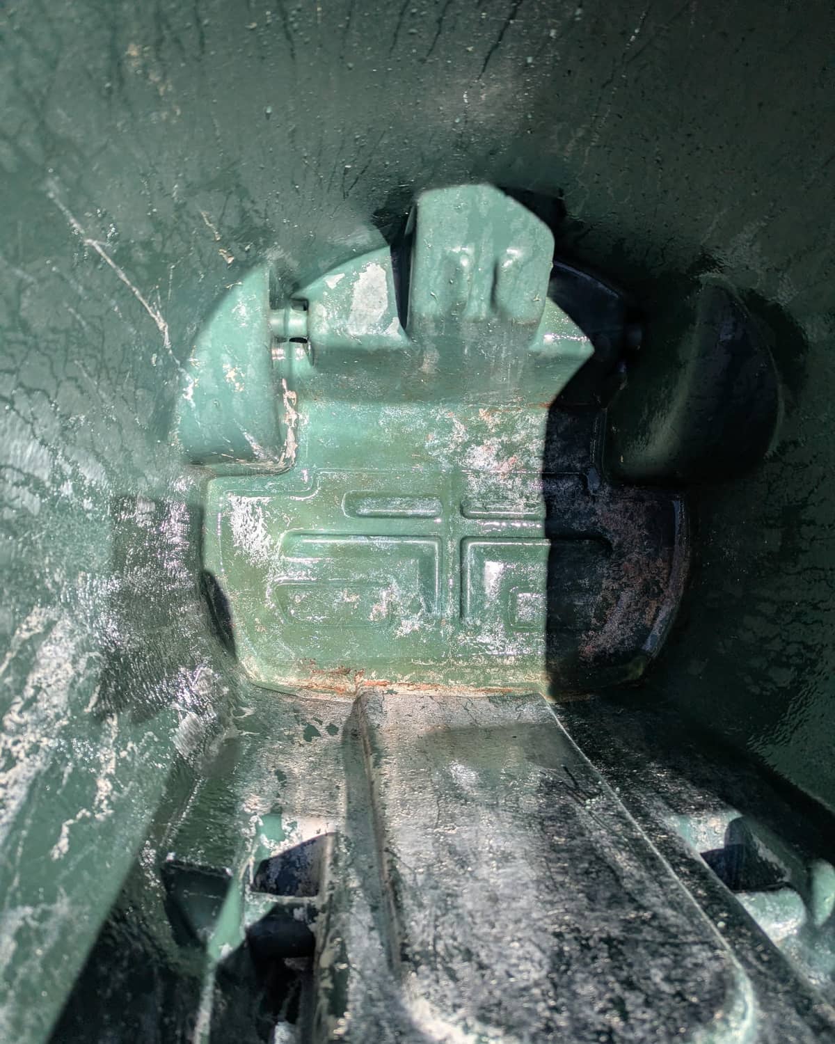 The same trash can after a hot-water pressure wash and sanitizing by Grand Valley Can Blasters, with the green plastic and molded detail visible again